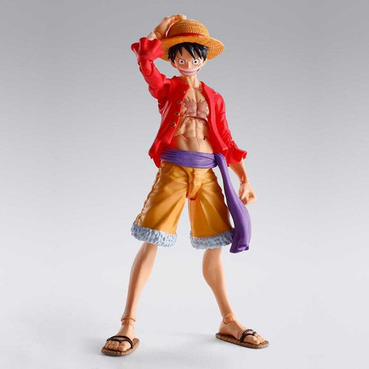 A detailed anime action figure of Monkey D. Luffy from One Piece, standing in a dynamic pose with his straw hat on his head, wearing a red jacket, yellow-orange shorts, and a purple sash, set against a plain light gray background.
