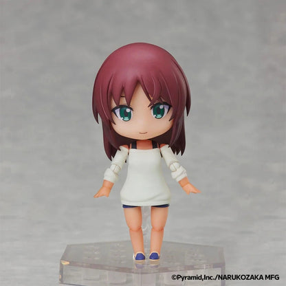 A chibi-style anime figurine with short burgundy hair, large teal eyes, and a white sleeveless dress, standing on a clear display base against a soft gray background.