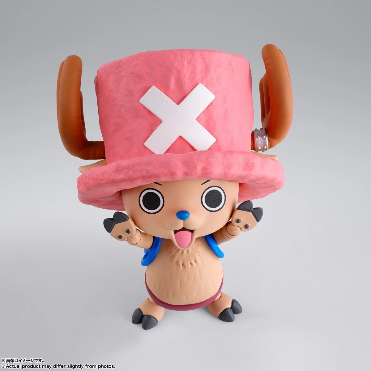 Toy figure with a pink hat featuring a white 'X' on a gray background