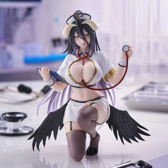 A detailed anime-style female doctor figurine kneeling on a white table, wearing a white nurse-style top with gold trim, a short white skirt, thigh-high stockings, and black wings, while holding a stethoscope and clipboard. The background is a softly blurred medical room setting.
